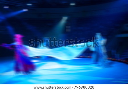 Abstract blurred image of tour of circus on ice. Skating on stilts in defocus, motion blur, background