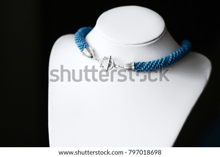 Blue bead crochet necklace on a dark background close up