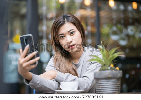Portrait beautiful girl are happily selfie in cafe. 