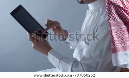 Saudi Arabian Man Hands Holding and Using Tablet Royalty-Free Stock Photo #797050252