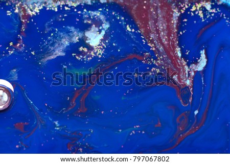 Colorful abstract composition. Colors dropped into liquid and photographed while in motion. Fancy paint background in concept blue space.