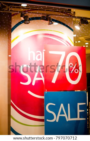 Boutique and Sale sign.Shop window display in the post about sales.announcement of a seventy-percentage discount on a glass show-window.discount sign on clothing store. shopping concept