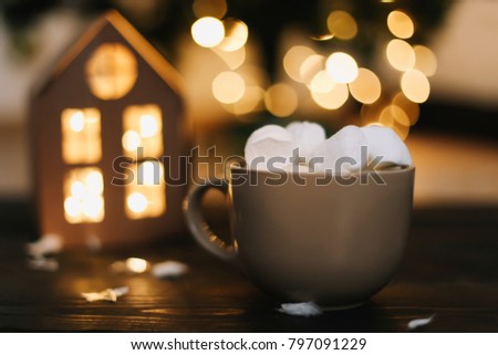 Christmas coffee cup with marshmallows. Still life on dark background. New Year's lights and decorations