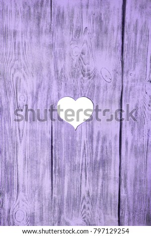 White heart carved in a wooden pink board. Background.