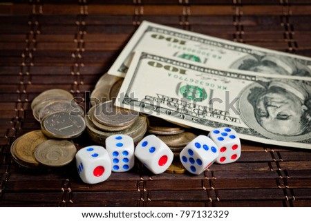 Dollars, dice and coins of different countries on a dark background