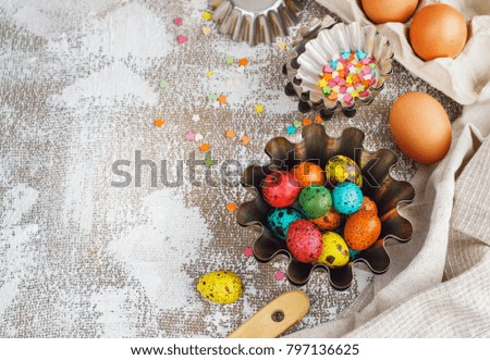 Colored easter eggs and baking molds on a light canvas background,place for text.