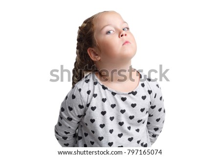 Offended little girl, sadly holding hands behind back. Isolated on white background.