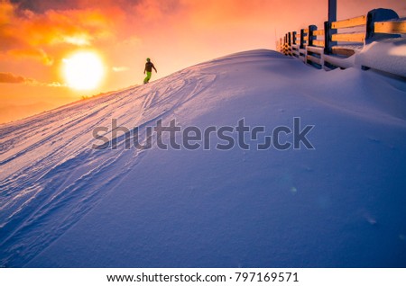 Snowboarder silhouette in winter ski resort.