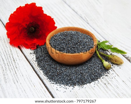 Bowl with poppy seeds and poppy flowers