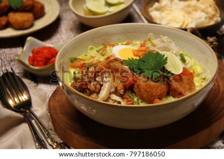 Soto Medan. Creamy coconut milk soup with fried chicken, glass noodles, bean sprouts, egg, and potato cake from Medan, North Sumatra. Royalty-Free Stock Photo #797186050