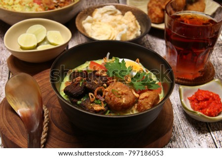 Soto Medan. Creamy coconut milk soup with fried beef cubes, glass noodles, bean sprouts, egg, and potato cake from Medan, North Sumatra. Royalty-Free Stock Photo #797186053