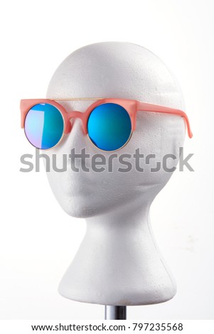 Fashion design glasses wearing on a white mannequin against white background. 