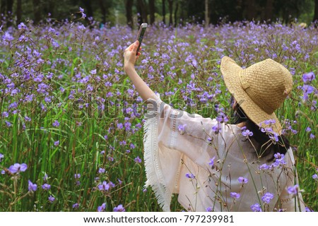 One Female Taking Selfie Picture in the Murdannia Flower Field with Her Mobile Smart Phone 