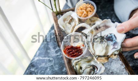 Fresh oysters on ice in wooden tray, food background,Delicious oyster in shell on ice,