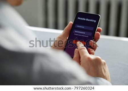 Man signs up for banking with his cell phone in the office