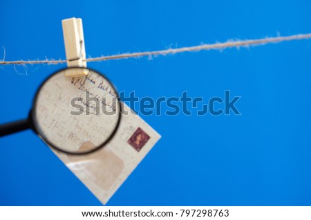 Envelope through a magnifying glass on a rope on a blue background