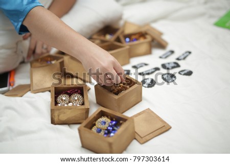 golden wooden boxes with earrings. a woman choosing it