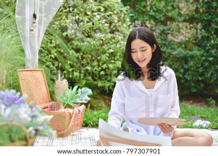 Concept Artist Beautiful girl. Beautiful women are creating art. Beautiful woman is painting happily. Young artist painting outside the house.