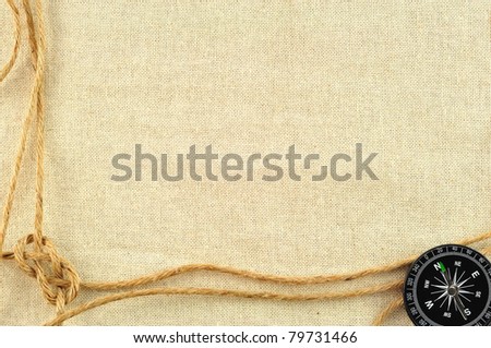 compass and rope on with a canvas of burlap
