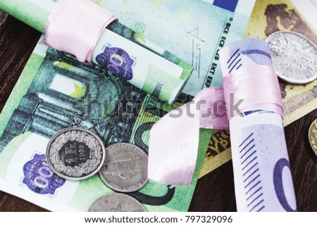 Euros of different denominations twisted into a tube