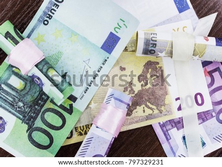 Euros of different denominations twisted into a tube
