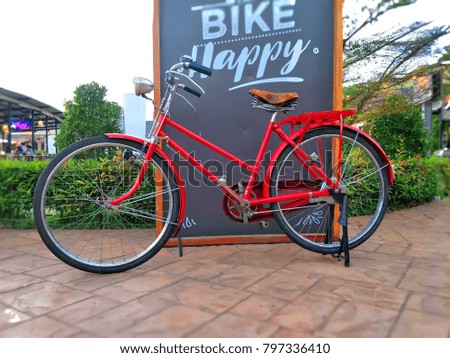 Red vintage bicycle parking on brown concrete floor in the garden