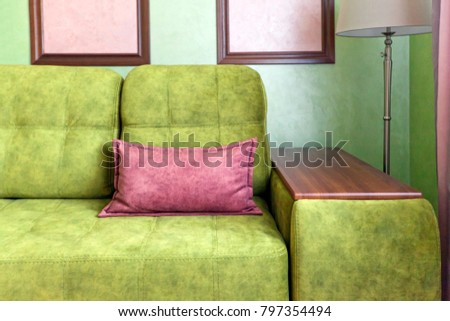 Fragment of the interior with a green sofa and picture cards