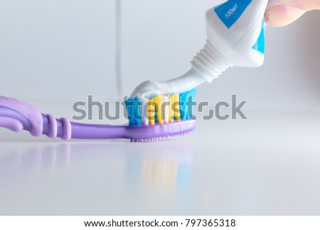 Toothbrush with applied toothpaste portion