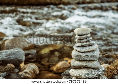 Stack of stones balancing on top in blue water of the river. nature background. Rock Stack A colorful Rock Stack along the banks of a river.