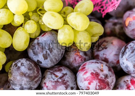 Fresh grapes and plum background