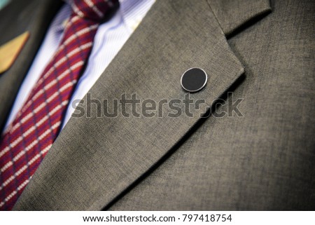 Mens suit Lapel pin closeup of tailored business suit and tie corporate meeting Royalty-Free Stock Photo #797418754