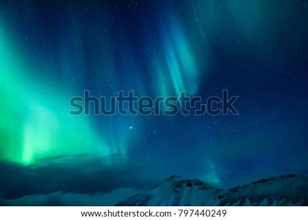 Amazing view on the Northen light over high mountains covering with snow, forces of nature, Aurora Borealis, Iceland Royalty-Free Stock Photo #797440249