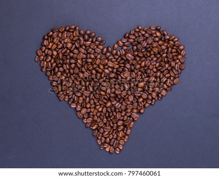 coffee beans in the form of heart on grey mat surface