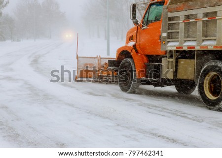 Tractor removing snow from residential housing estate in winter