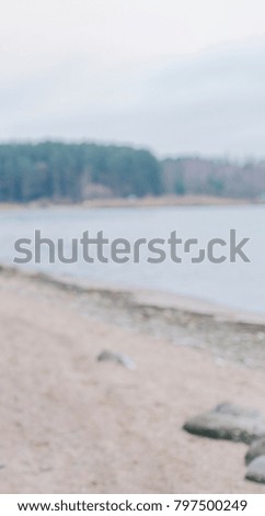 Lake landscape with cloudy sky in autumn time, defocused