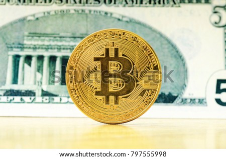 Bit coin with a dollar banknote background.