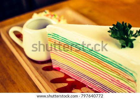 close-up image of rainbows crape cake with strawberry sauce 