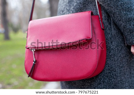 Close up picture of red leather handbag outdoor on wintertime