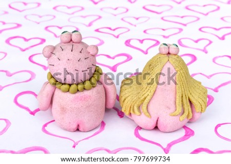 Toys "man" and "woman" from dough and salt . Valentine's day . Handmade. Pattern "heart" , as a horizontal  background .