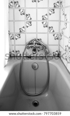 Old bathroom with vintage tiles. Retro bath in grayscale.