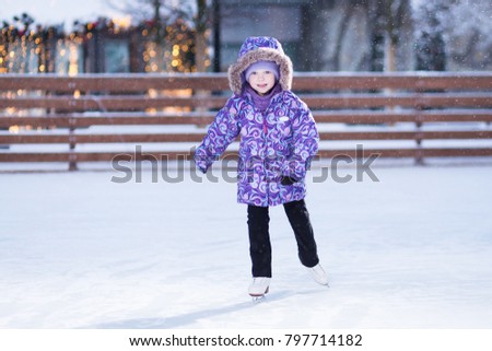 Adorable girl skating on the outdoor rink