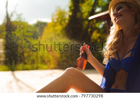 Girl applying sunscreen on her legs