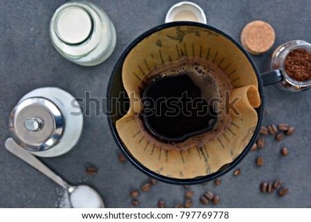 filtered coffee in a cup with milk and sugar beside it
