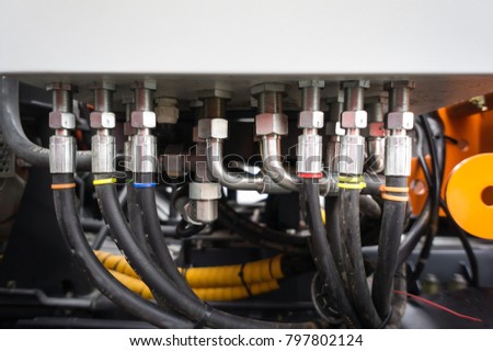 Close up of pipe system of hydraulic valves in agricultural machinery.