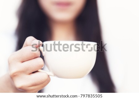Young woman drinking coffee in the sun, outdoor in sunlight light, enjoying her morning coffee.