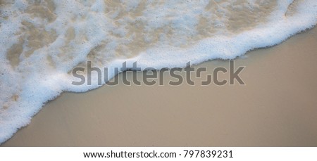 Background photo Water and sea bubbles on the sandy beach.