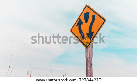 Divided road begins highway sign with blue sky background
