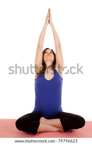 A pregnant woman sitting down stretching up his arms.