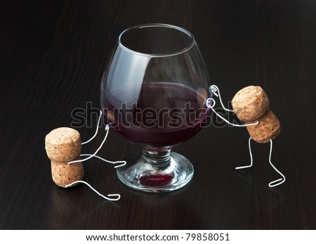 Figures from wine corks and a glass of wine