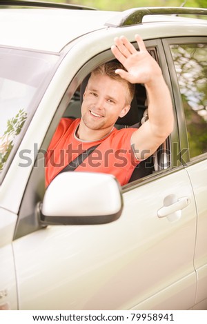 Driver of car waves hand as a sign of greeting.
